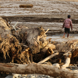 Un hombre andando por una zona arrasada por las inundaciones en Sumatra (Indonesia).