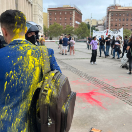 Imatge d'arxiu d'un congressista tancat de pintura quan entrava a The District, amb manifestants al fons