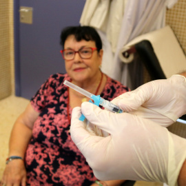 Una pacient mira la vacuna de la grip que li preparen en una consulta del CAP Baix Ebre de Tortosa