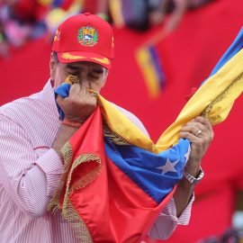 El presidente de Venezuela, Nicolás Maduro, besa una bandera durante una movilización este lunes en Caracas. .