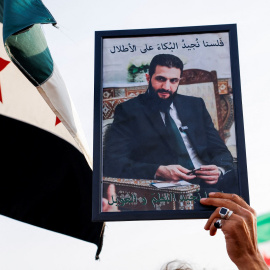 Una persona sostiene una imagen del presidente sirio Ahmed al-Sharaa durante una manifestación en apoyo a la unidad territorial siria y contra la división, en Damasco.
