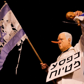 Un manifestante sostiene una muñeca en una protesta contra el primer ministro israelí, Benjamin Netanyahu, y su gobierno, en Tel Aviv.