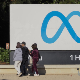 Imagen de archivo que muestra a varias personas caminando frente a las oficinas de Meta.