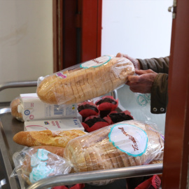 Una persona recoge comida en un comedor social. Archivo.
