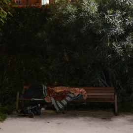 Una persona dormint en un banc a Barcelona a principis del desembre del 2025.