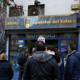 Varias personas hacen cola en una administración de lotería.