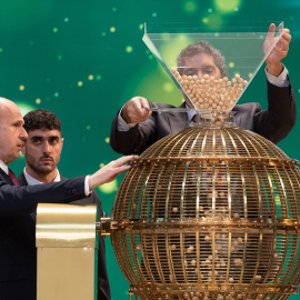 Varios hombres preparan el bombo para el Sorteo Extraordinario de la Lotería de Navidad.