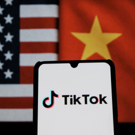 El logo de TikTok entre las banderas de EEUU y de China.