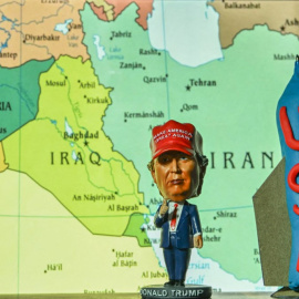 Una estatua en miniatura del presidente estadounidense Donald Trump junto a una maqueta de una bomba antibúnker, con un mapa de Oriente Medio e Irán como telón de fondo, expuesta en Kananaskis,(Canada) 19/06/25