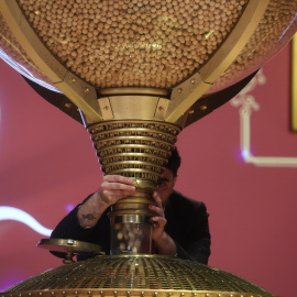 Varias personas rellenan los bombos del Sorteo Extraordinario de la Lotería de Navidad 2025, en el Teatro Real, a 22 de diciembre de 2025, en Madrid.