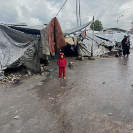 Palestinos desplazados caminan en un campamento de tiendas inundado tras las fuertes lluvias en la ciudad de Gaza.
