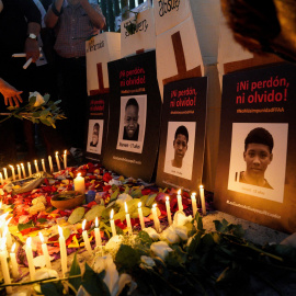 Fotografías con el rótulo de "Ni perdón ni olvido" de los cuatro niños desaparecidos y posteriormente encontrados muertos, durante una vigilia por el primer aniversario de su desaparición, en el barrio Las Malvinas de Guayaquil (Ecuador).