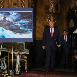 El presidente de Estados Unidos, Donald Trump, pasa junto a una representación de los acorazados 'Clase Trump'.