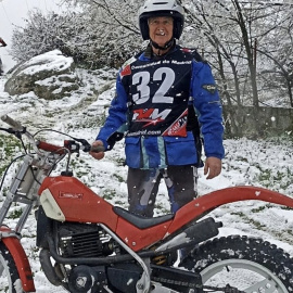 Gonzalo de Lecea, junto a su moto, a sus 70 años, en plena nieve.