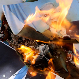 Los somalíes queman la bandera de Israel y una imagen que representa al primer ministro israelí, Benjamin Netanyahu, durante una manifestación contra la decision de Tel Aviv de reconocer a la República de Somalilandia