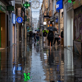 Varias personas caminan con paraguas, a 20 de diciembre de 2025, en Badalona, Barcelona, Catalunya (España).