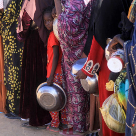 Una niña sudanesa que huyó de El-Fasher hace fila junto a otras mujeres para recibir una comida gratuita en el campamento de Al-Afad para personas desplazadas, al norte de Sudán (20.11.2025)