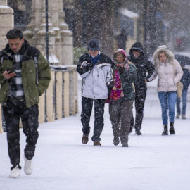 Varias personas caminan por Teruel bajo la nevada.