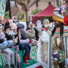 El Rei Baltasar saluda alguns dels infants que han anat a esperar els Reis d'Orient al Portal de la Pau de Barcelona.