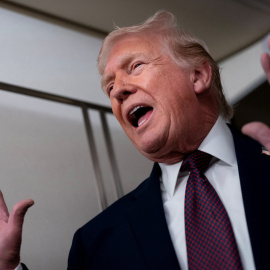 El presidente de EEUU, Donald Trump, atiende a los medios en su avión presidencial.