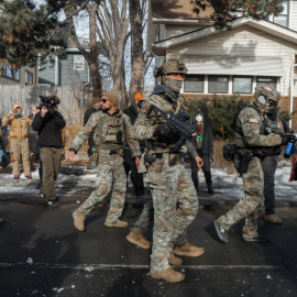 Agentes del ICE caminan por un vecindario durante un enfrentamiento en Minneapolis, Minnesota.