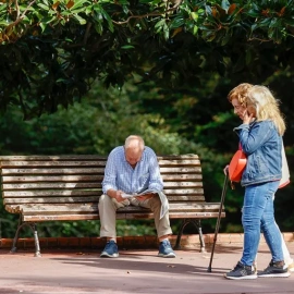Un senior en el parque ante la mirada de dos mujeres