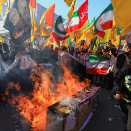 Partidarios de grupos armados chiítas iraquíes queman ataúdes simulados con banderas israelíes y estadounidenses durante una manifestación en solidaridad con el Gobierno de Irán en Teherán (16.01.26)