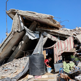 Una niña palestina desplazada que vive entre los escombros y restos de viviendas destruidos por el ejército israelí llena un recipiente con agua en el campo de refugiados de Jabalia, al norte de la Franja de Gaza (17/01/26)