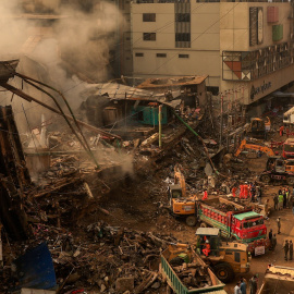 Los equipos de rescate utilizan maquinaria pesada para retirar los escombros del centro comercial Gul Plaza, tras su incendio, en Karachi (Pakistán).