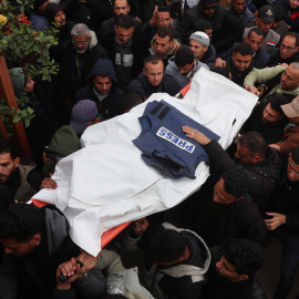 Palestinos cargan los cuerpos de palestinos asesinados por fuego israelí.