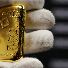 Un empleado sostiene un pequeño lingote de oro en una tienda en Barcelona.