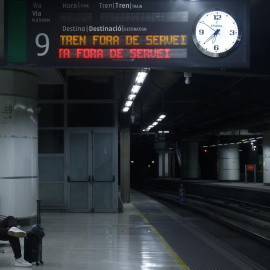 Un pasajero espera un tren en la estación de Sants de Barcelona.