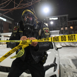 Un agente coloca cinta adhesiva en Maple Grove, en Mineápolis, ante protestas contra el ICE.