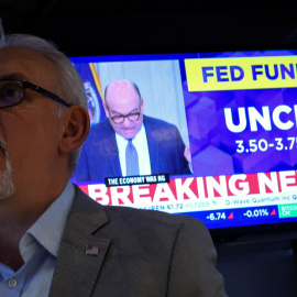 Un monitor de televisión informa de la decisión de la Reserva Federal (Fed) de mantener los tipos de interés, en el patio de negociación de la Bolsa de Nueva York (NYSE), en Wall Street.