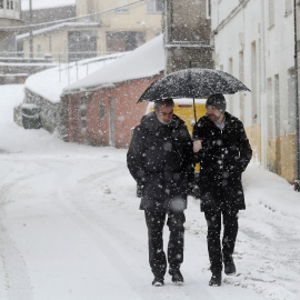 Dos personas cubriéndose de la nieve en Pedrafita do Cebreiro, Lugo.