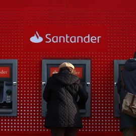 Varios clientes utilizan cajeros automáticos del Banco Santander, en una imagen de archivo.