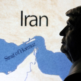 Un mapa que muestra el estrecho de Ormuz e Irán se ve detrás de una miniatura impresa en 3D del presidente estadounidense Donald Trump.