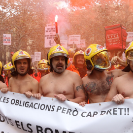 Bombers voluntaris protesten davant el Departament d’Interior i alguns d'ells s'han tret la roba per visibilitzar la “desprotecció” amb què treballen en una imatge d'arxiu