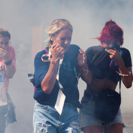 Varias mujeres corren entre los gases lacrimógenos de la policía, en los enfrentamientos por la reforma laboral de Milei.