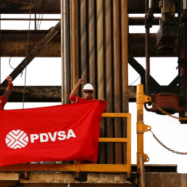 Unos trabajadores sostienen una bandera con el logo de PDVSA en una plataforma de perforación en la rica petrolera del Orinoco (Venezuela), en una imagen de archivo.