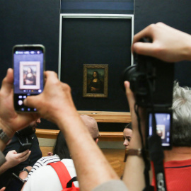 Turistas toman fotos con sus móviles al cuadro de 'La Gioconda', o 'Mona Lisa', en su sala del Museo del Louvrre, en una imagen de archivo.