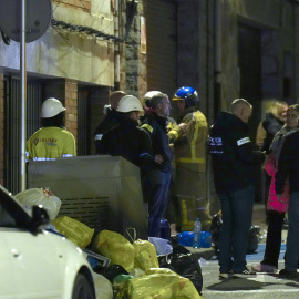 Vista de la entrada del edificio en el que cinco personas han muerto y otras cuatro han resultado heridas de carácter leve en un incendio registrado en un bloque de pisos en la localidad barcelonesa de Manlleu.