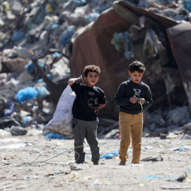 Niños palestinos caminan cerca de un vertedero, en la ciudad de Gaza