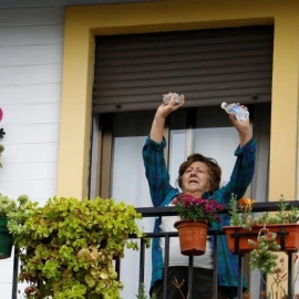 Una mujer saluda desde el bálcón de su casa en Córdoba.