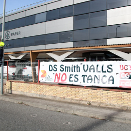 L'exterior de la planta d'International Paper de Valls amb un cartell que denuncia el tancament