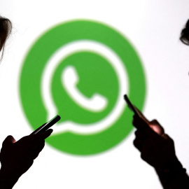 Las siluetas de unos jóvenes con sus móviles junto al logo de WhatsApp.