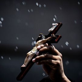 Una persona sostiene un crucifijo. Imagen de archivo.