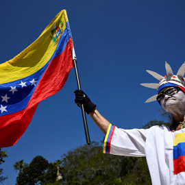 Una persona vestida como la Estatua de la Libertad sostiene una bandera venezolana en Caracas el 12 de febrero de 2026.