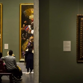 Varias personas se sientan mientras observan cuadros en el Museo del Prado de noche, a 4 de marzo de 2023, en Madrid (España).
