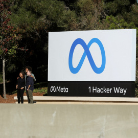 Un grupo de personas se hace una foto junto al logo de Meta, en su sede en Menlo Park (California, EEUU).
